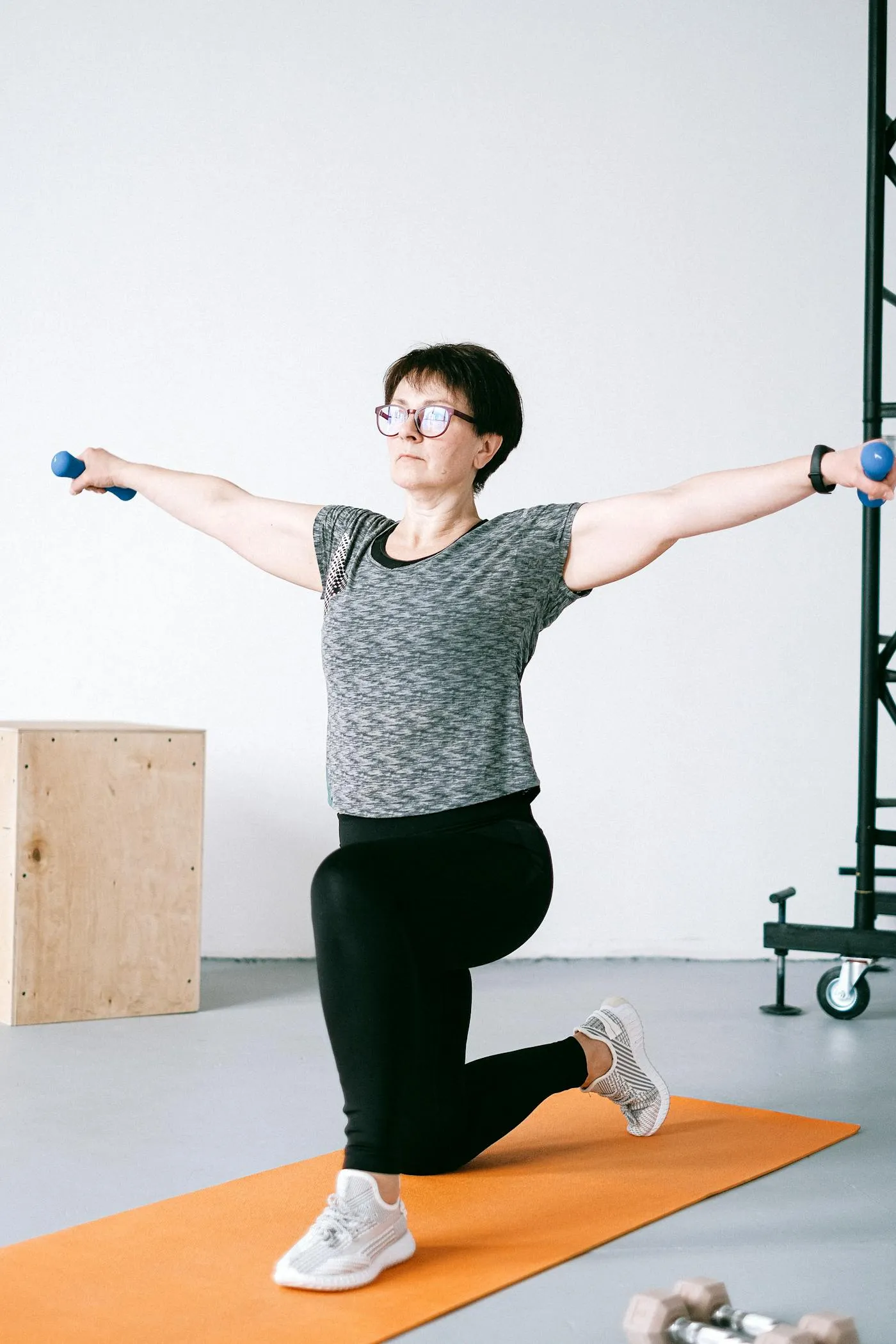 Mujer adulta entrenando equilibrio y fuerza con mancuernas ligeras
